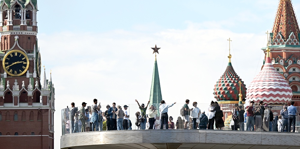 Люди стоят на мосту на фоне Красной площади
