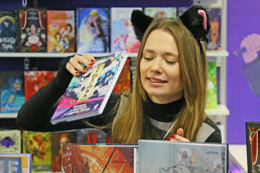 Девушка на стенде продажи графических романов.