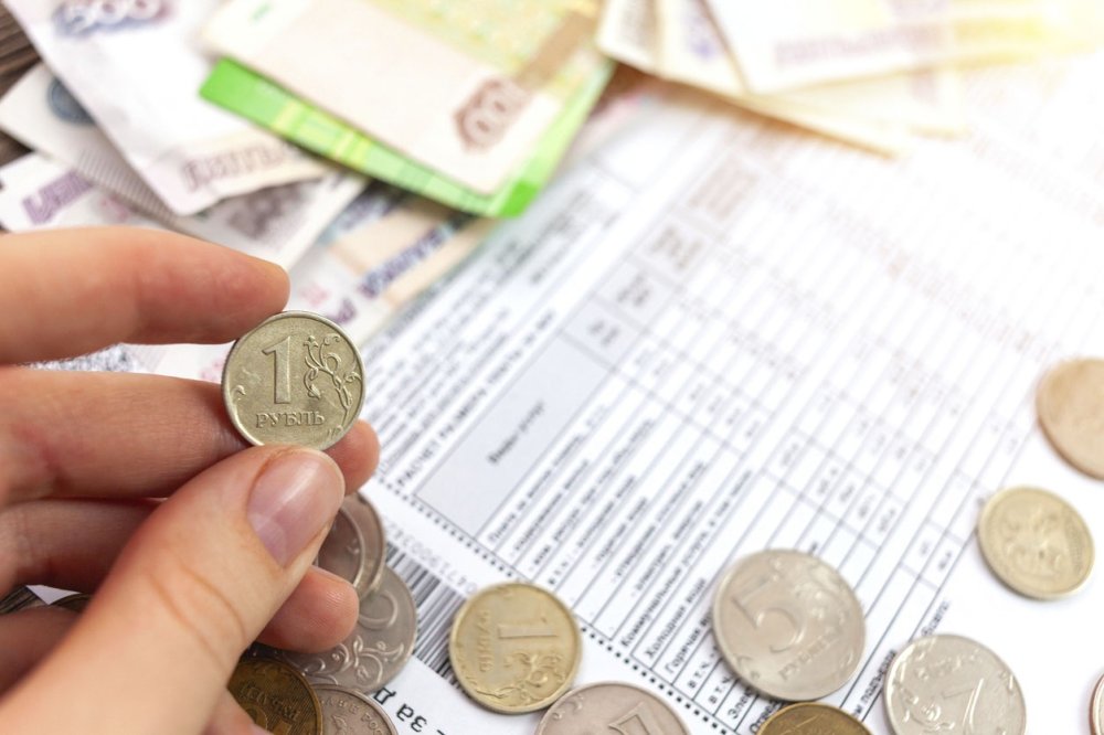 Несколько счетов за коммунальные услуги и небольшая пачка денег на столе.