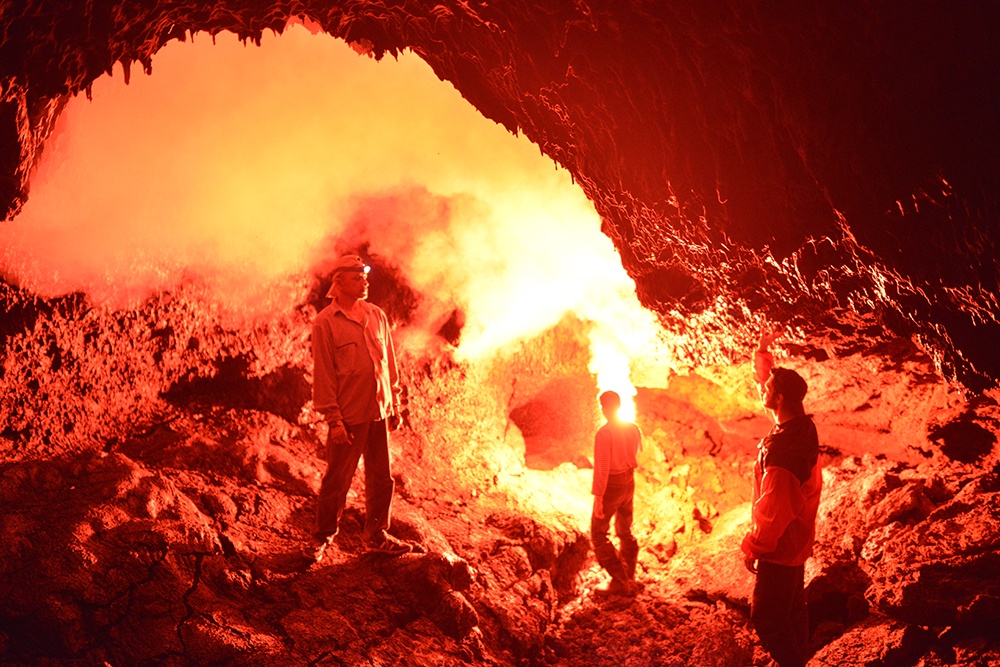 Туристы в лавовой пещере конуса в Камчатском крае