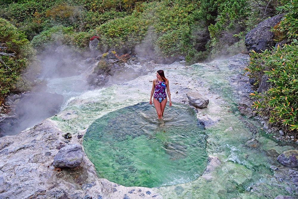 Туристка в источниках на склоне вулкана Баранского на острове Итуруп