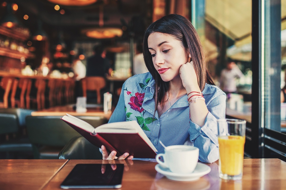 Девушка читает во время завтрака