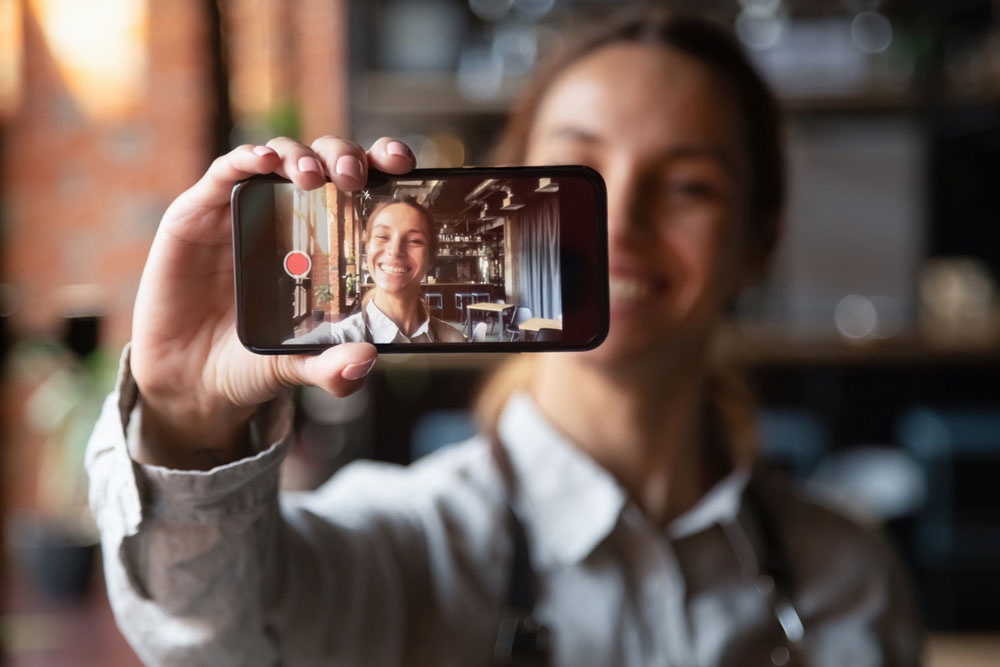 Девушка держит в руке смартфон