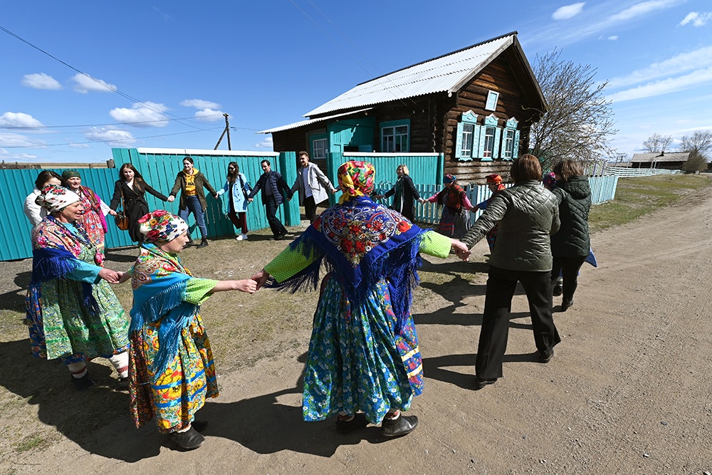 туристы водят хоровод со старообрядцами