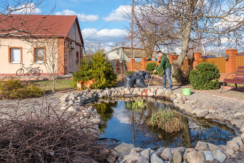 Мужчина чистит пруд