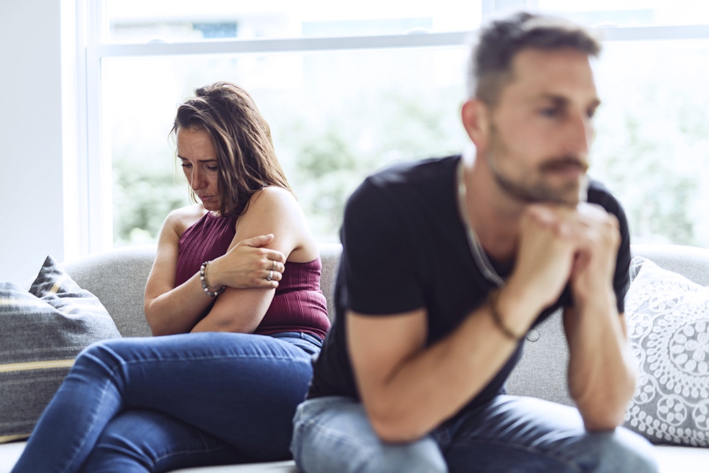 мужчина и девушка сидят на диване, девушка растроена