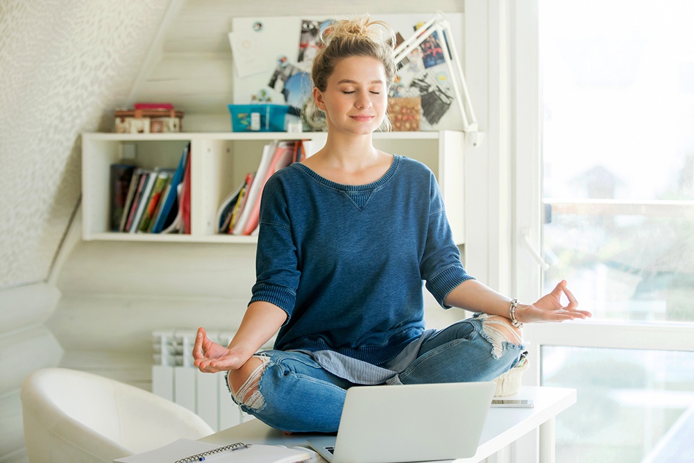 женщина медитирует сидя на столе