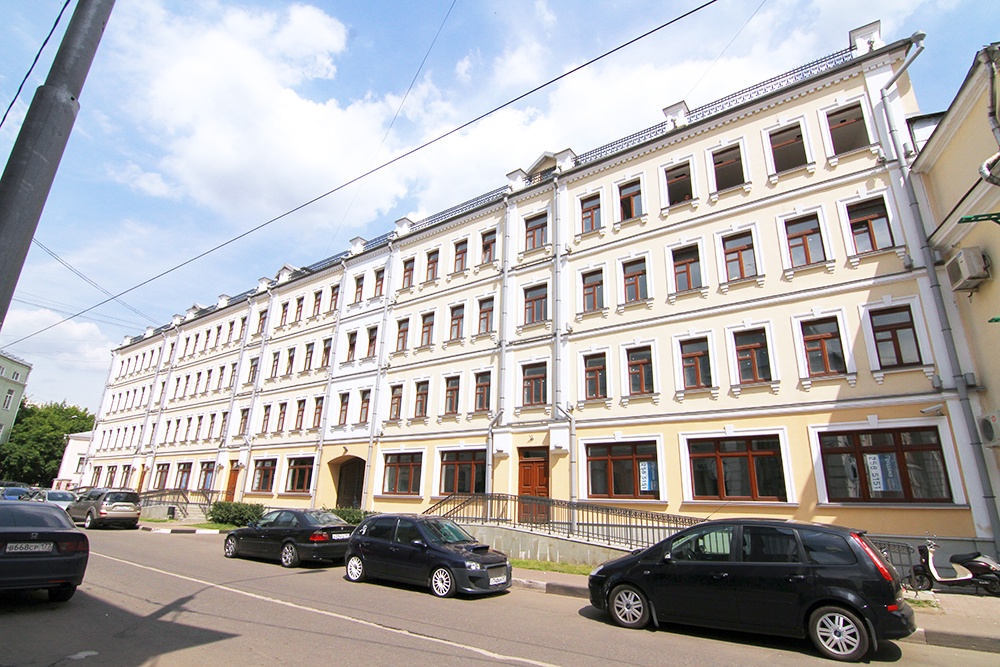 Автомобили припаркованы возле клубного дома