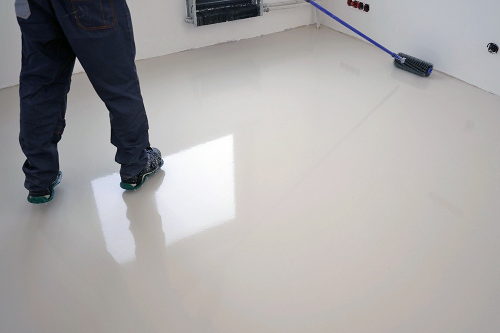 мужчина разравнивает наливной пол в комнате