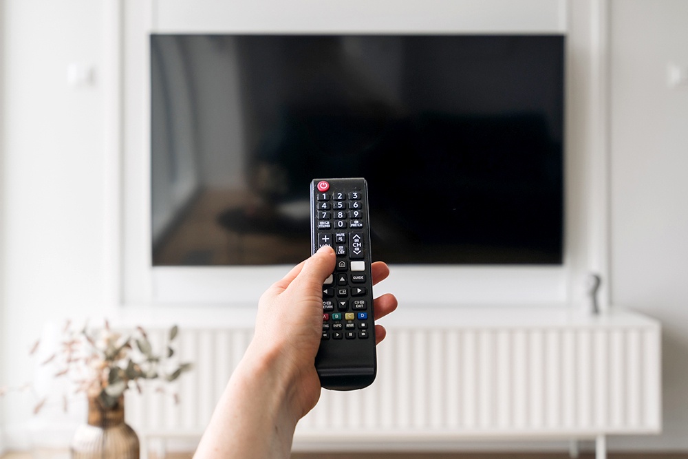 рука держит пульт от телевизора