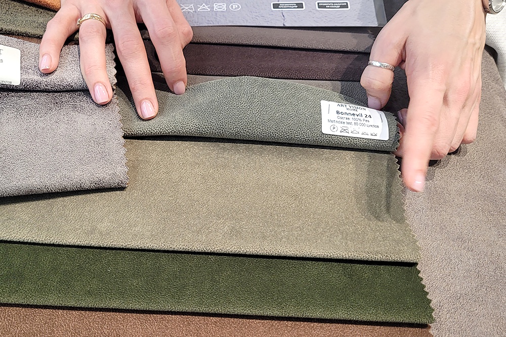 Девушка выбирает ткань дляобивки дивана