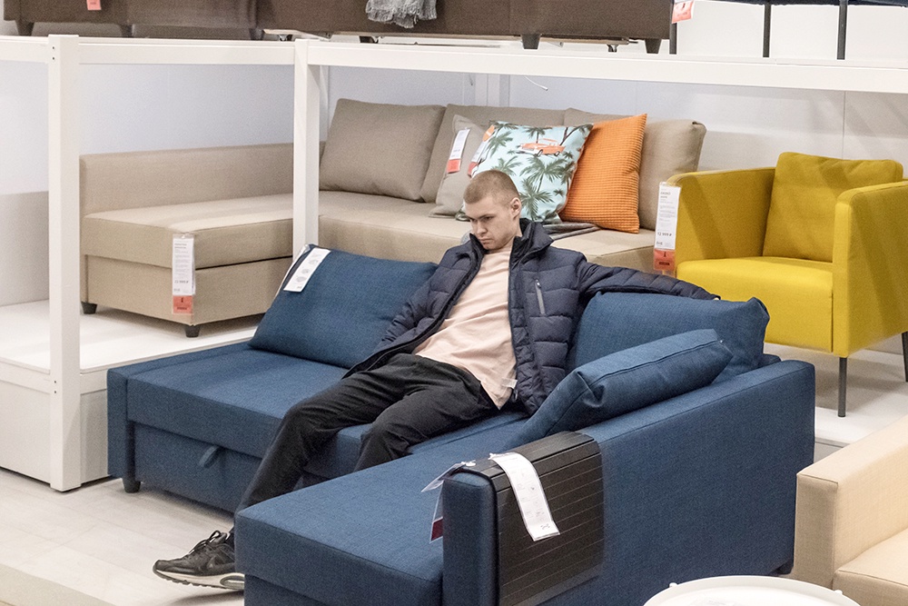 Мужчина сидит на диване в магазине