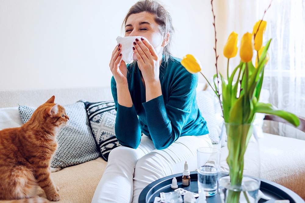 Девушка держит плоток у носа из-за аллергии