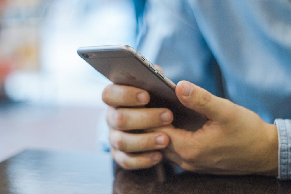 мужчина держит смартфон
