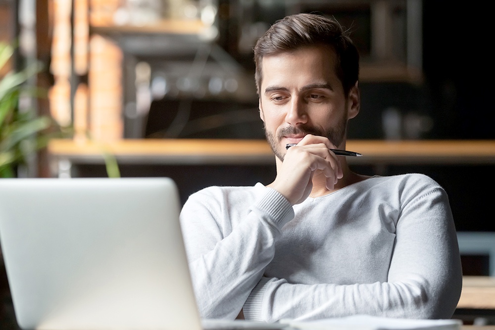 Мужчина смотрит в экран ноутбука