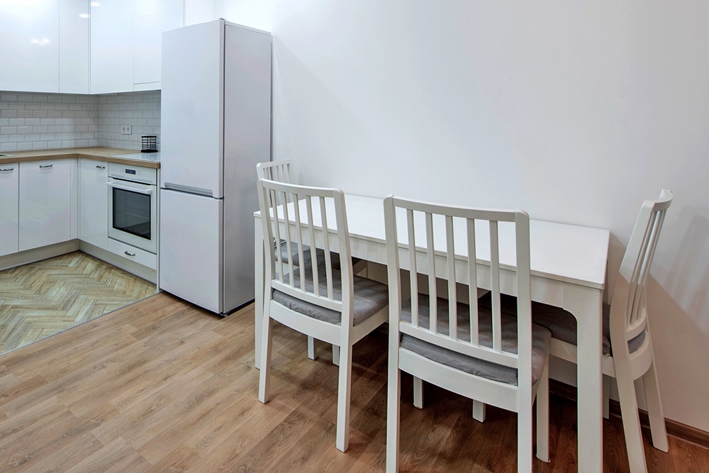 белый стол у стены на кухне