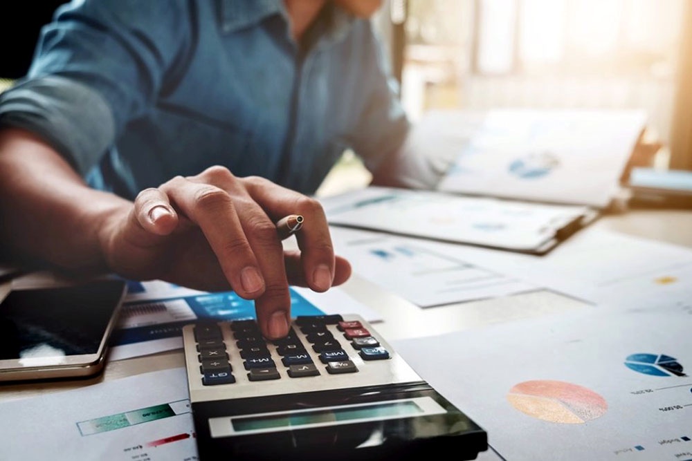 Мужчина считает на калькуляторе