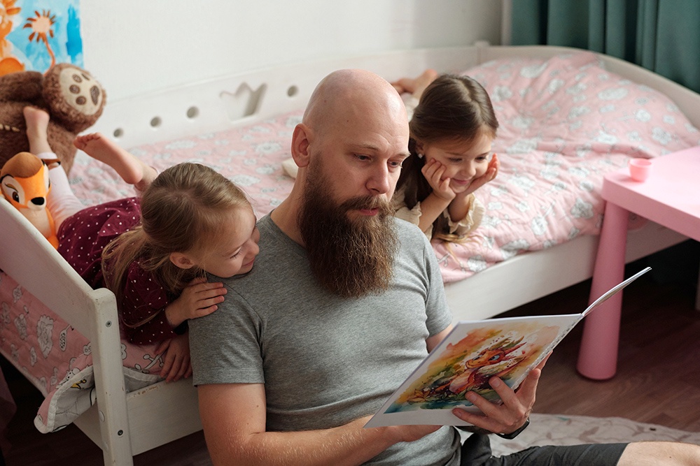 отец читает книгу детям