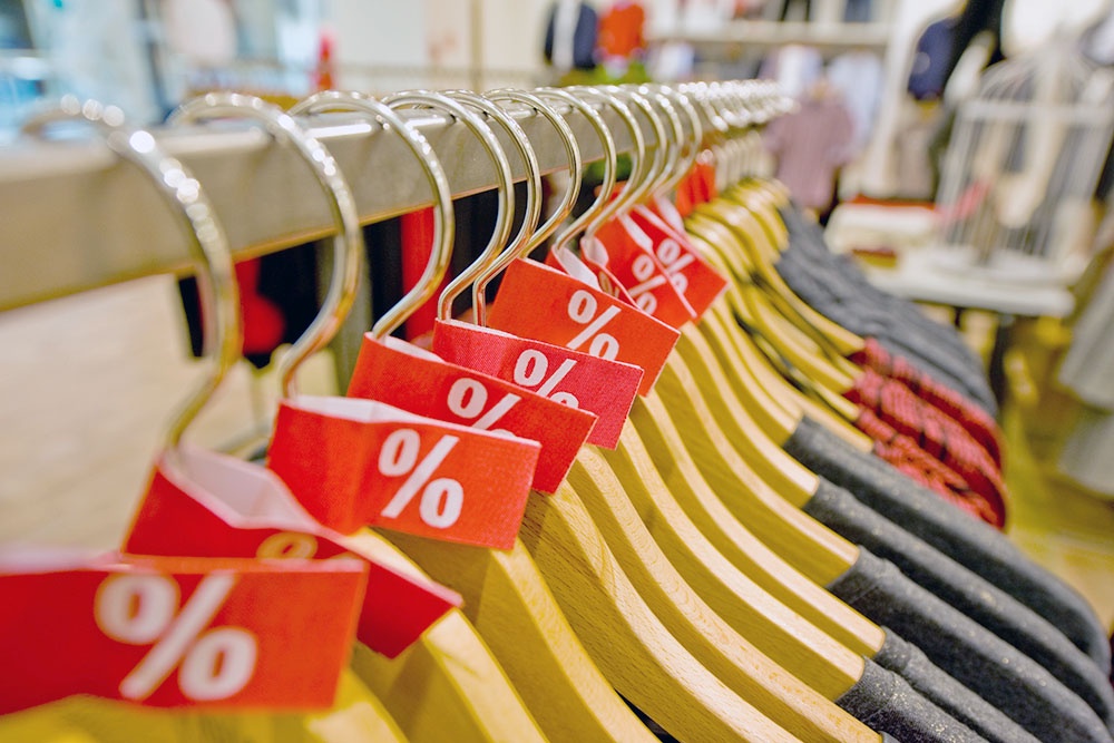 Вешалки со скидками висят в магазине.