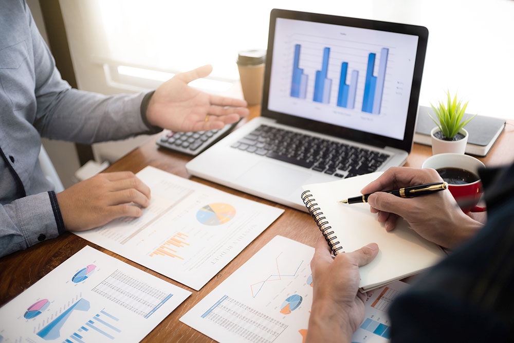 Мужские руки показывают таблицы на ноутбуке