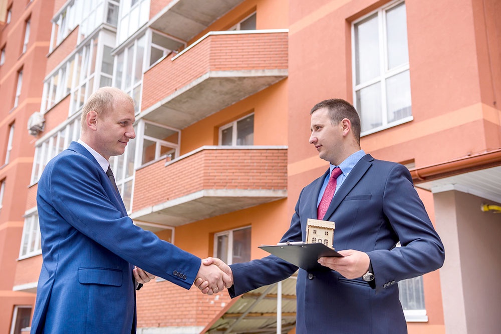 Мужчины заключают сделку по покупке жилья