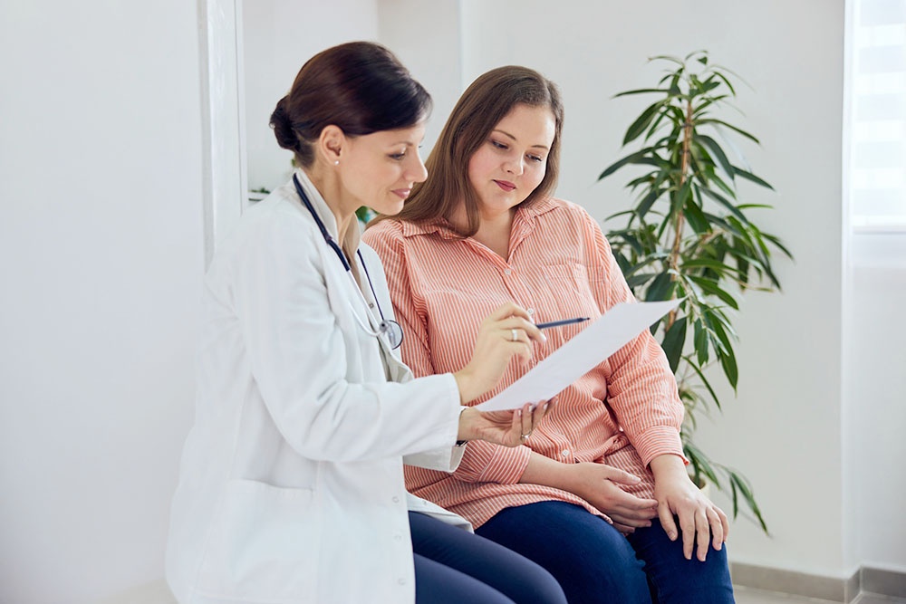 Женщина-врач показывает женщине-пациентке анализы