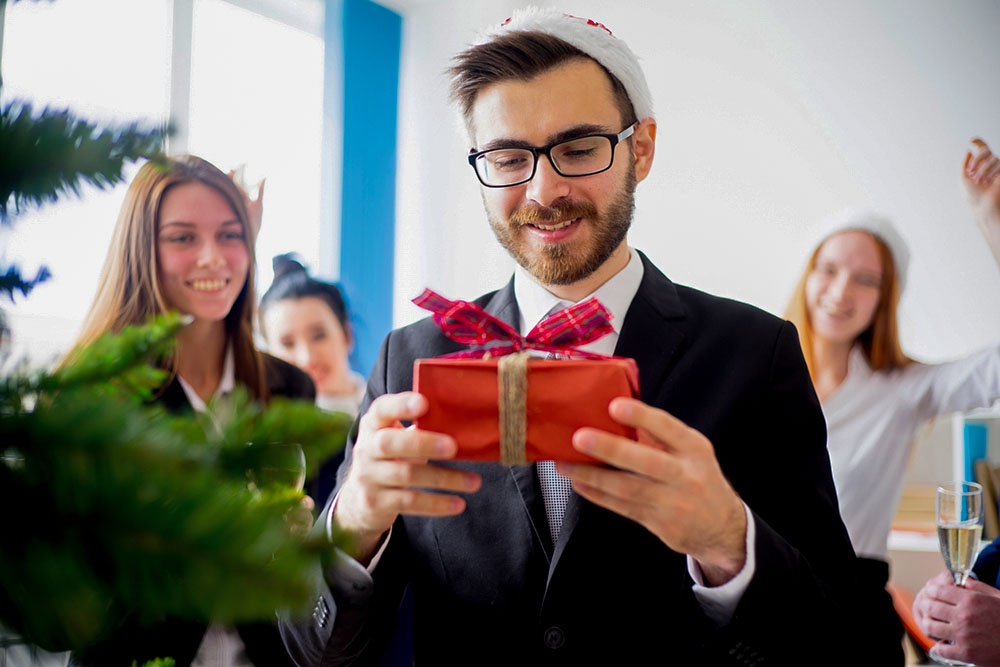 Офисный работник получает новогодний подарок от коллег