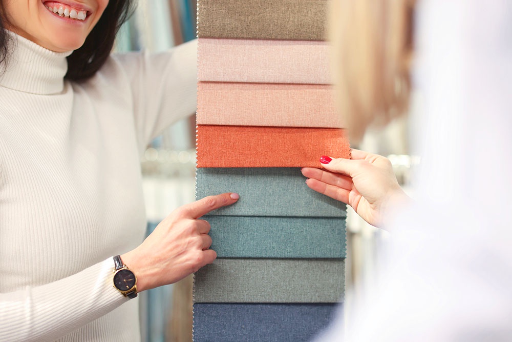 женщина показывает образцы ткани
