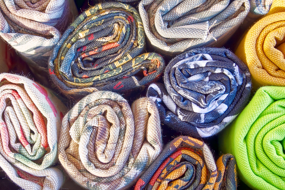 скрученные рулоны разноцветных штор