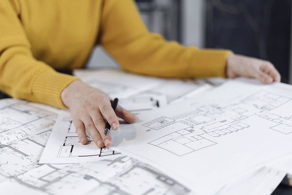 Дизайнер смотрит на план квартиры