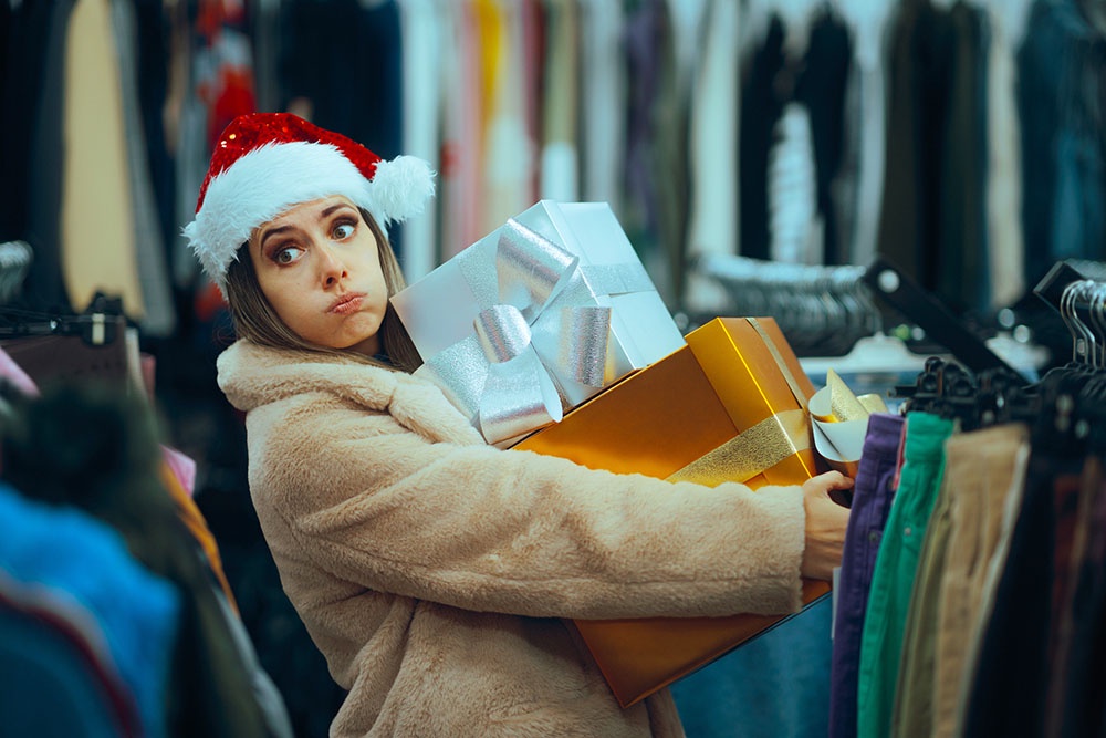 Женщина в магазине со стопкой упакованных подарков