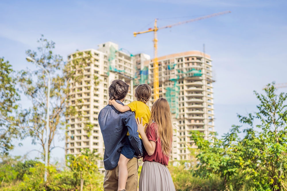 Молодая семья смотрит на строящийся дом