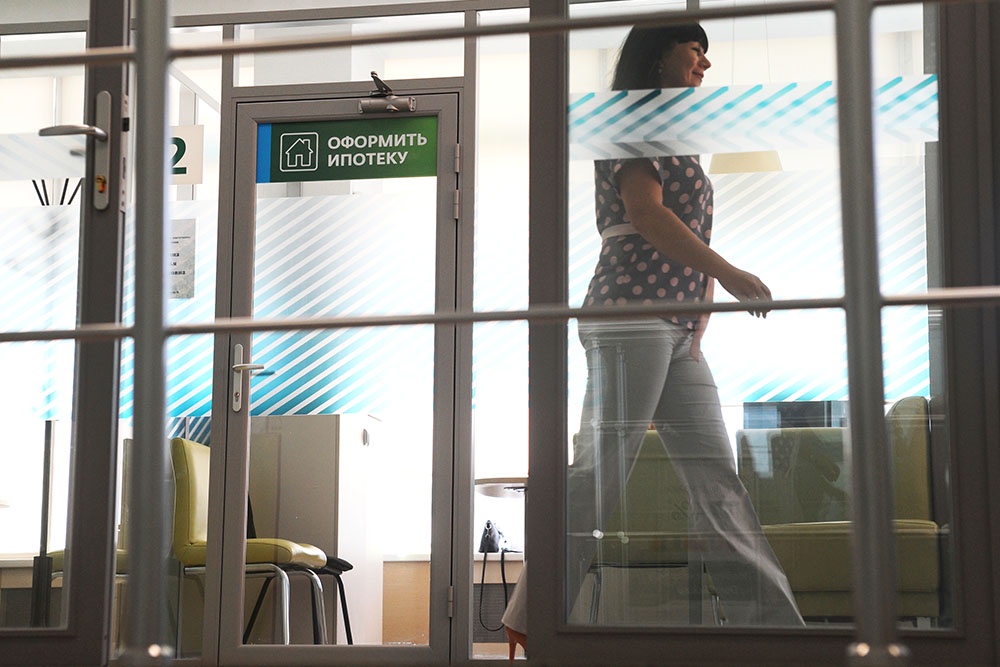 Женщина в офисе банка в отделении по оформлению ипотеки