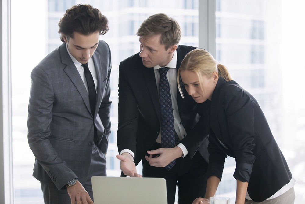 Мужчина обсуждает с коллегами решение сложных бизнес задач