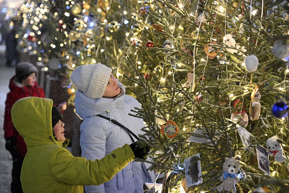 Дети на новогоднем гулянии в городе у елки