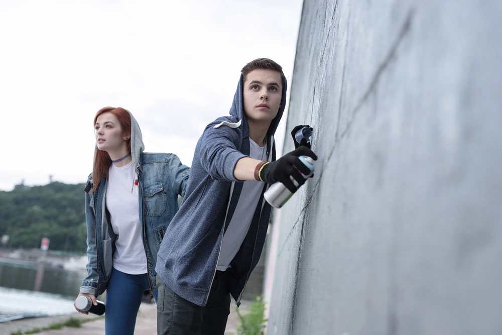 девушка и молодой человек рисуют граффити