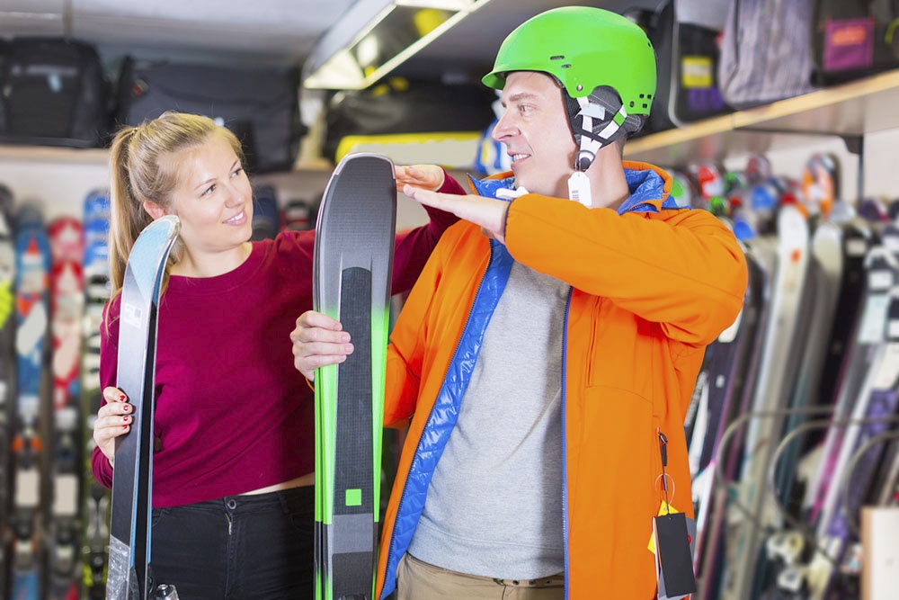 мужчина выбирает лыжи в магазине