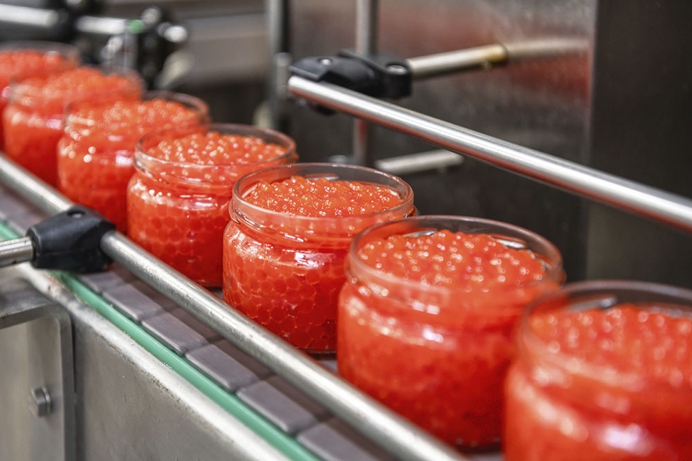 Банки с икрой на конвейере