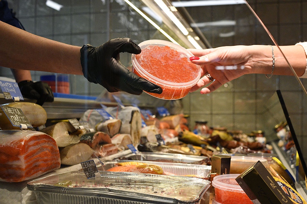 Человек покупает красную икру