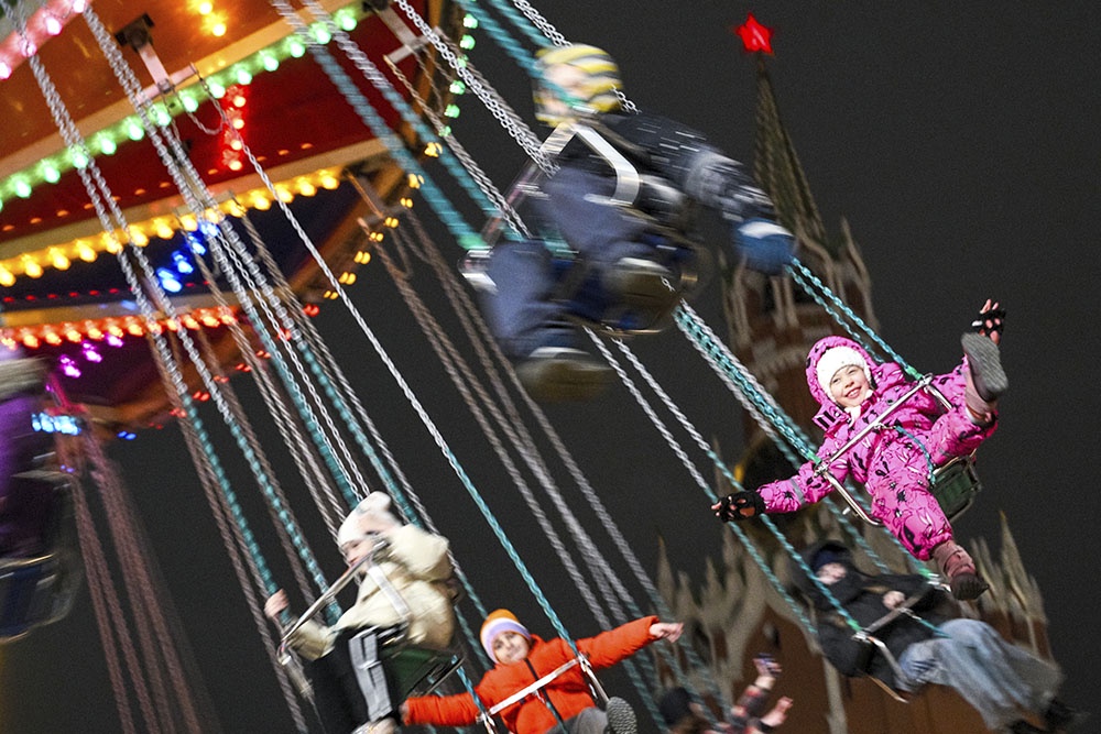 дети катаются на каруселях