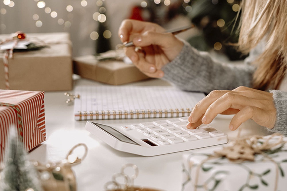 Девушка считает расходы на калькуляторе