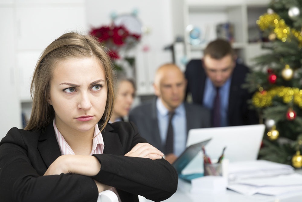 Женщина тревожно слушает совещание на работе