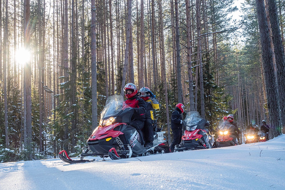 люди едут на снегоходах