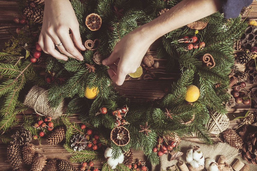человек делает новогодний декор своими руками 