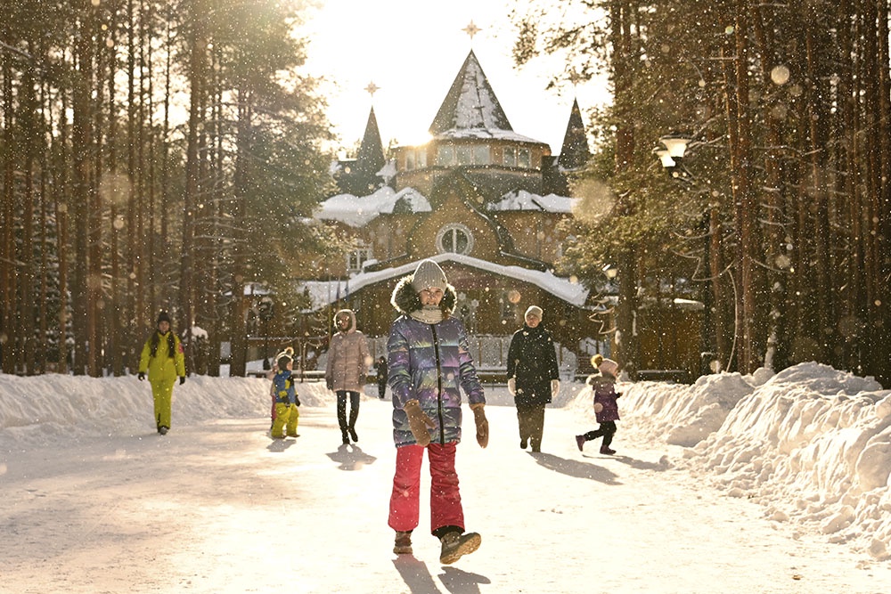 дети гуляют зимой у резиденции Деда Мороза