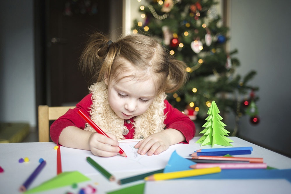 Девочка рисует сидя за столом