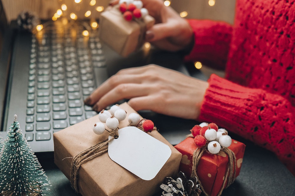 Человек пишет новогоднее поздравление на компьютере