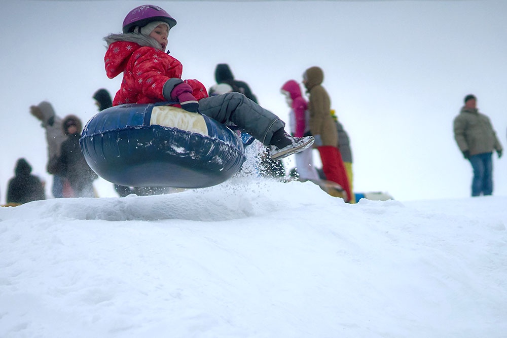 Девочка катается на тюбинге