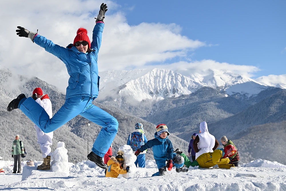 Дети с родителями на горнолыжном курорте празднуют Всемирный день снега