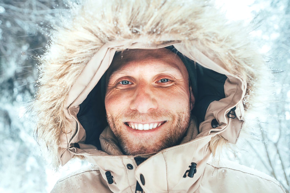 Мужчина в теплой куртке с меховой опушкой